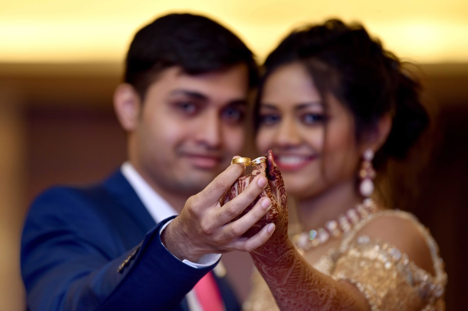 Newly married couple holding their wedding rings together